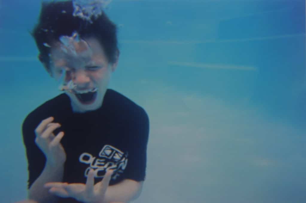 photo of boy screaming underwater