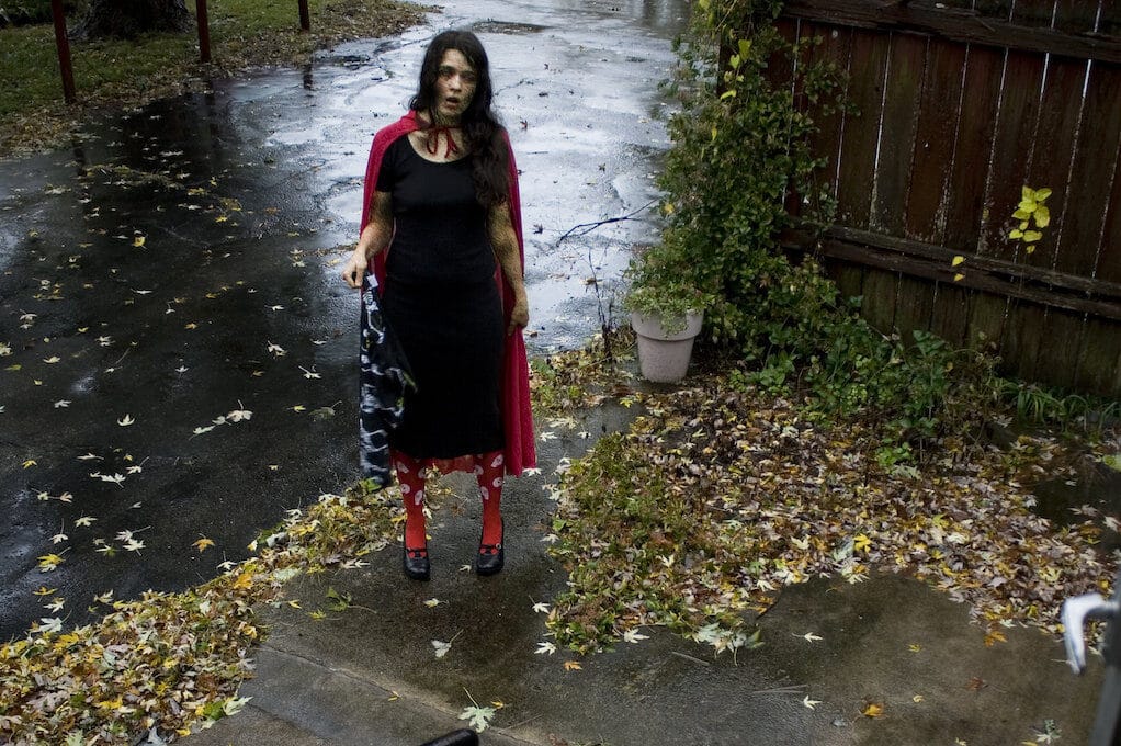 photo of female zombie standing at bottom of front porch stairs