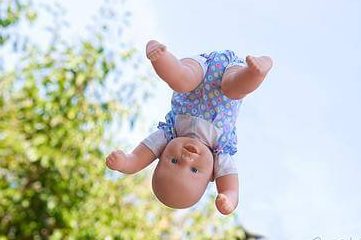 photo of a baby doll in midair