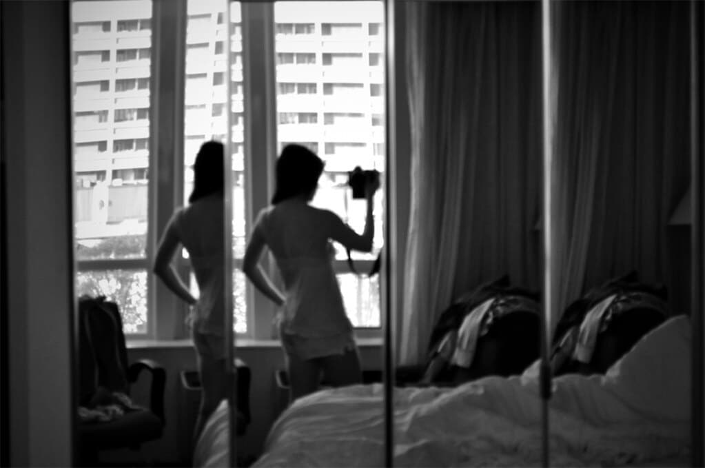 woman in bedroom holding camera