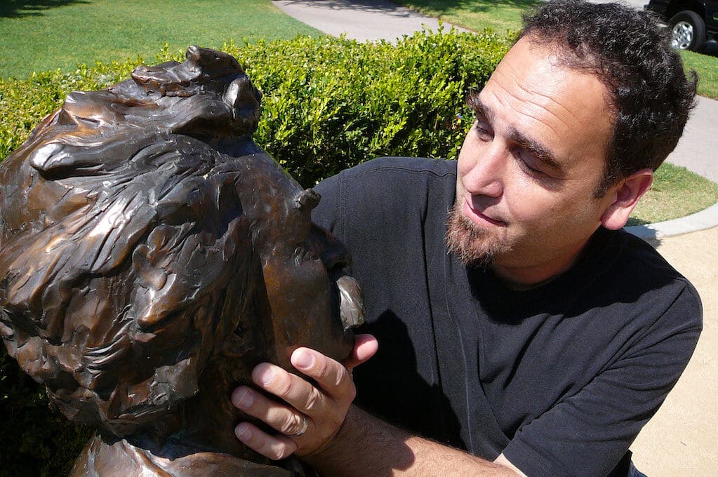 photo of man caressing the face of a Mark Twain statue