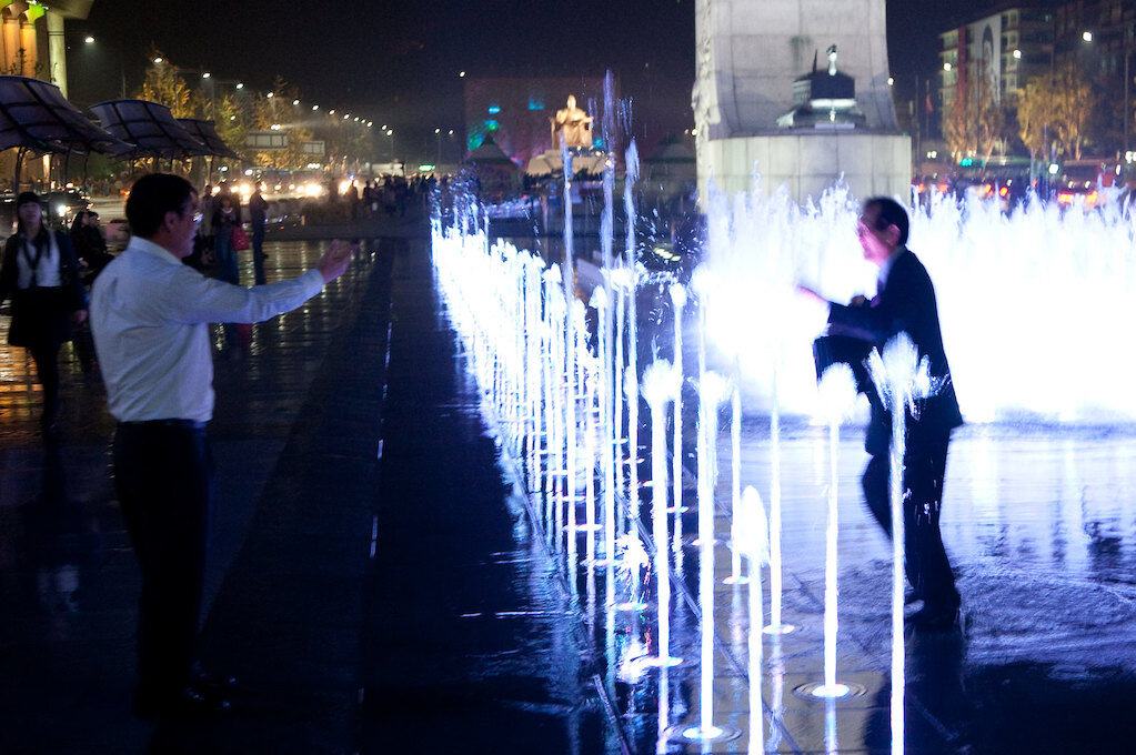 photo of drunk Korean business man playing in a fountain