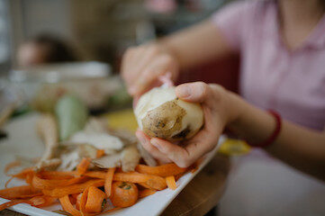 photo of person peeling potatoes in a kitchen