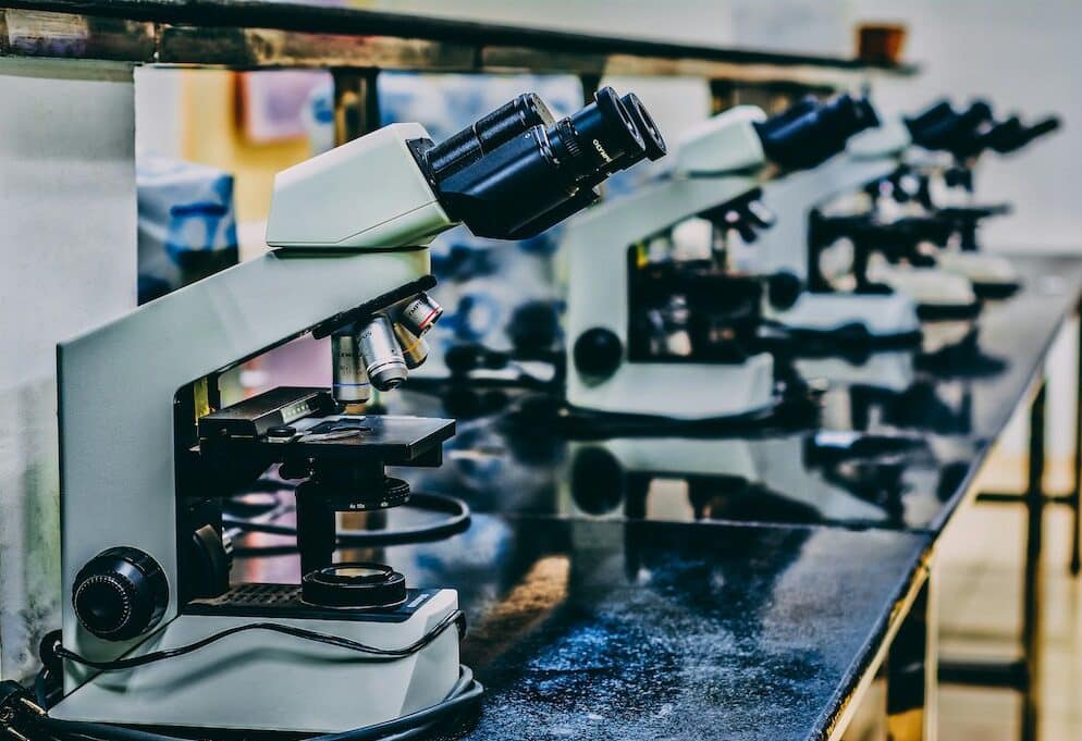 photo of white microscope on black table